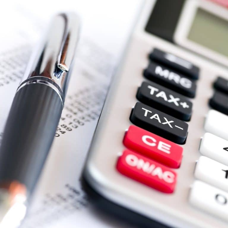 עט מונח על מסמך ליד מחשבון עם כפתור "TAX+" בולט, מרמז על המורכבות של מיסוי חברה משפחתית.